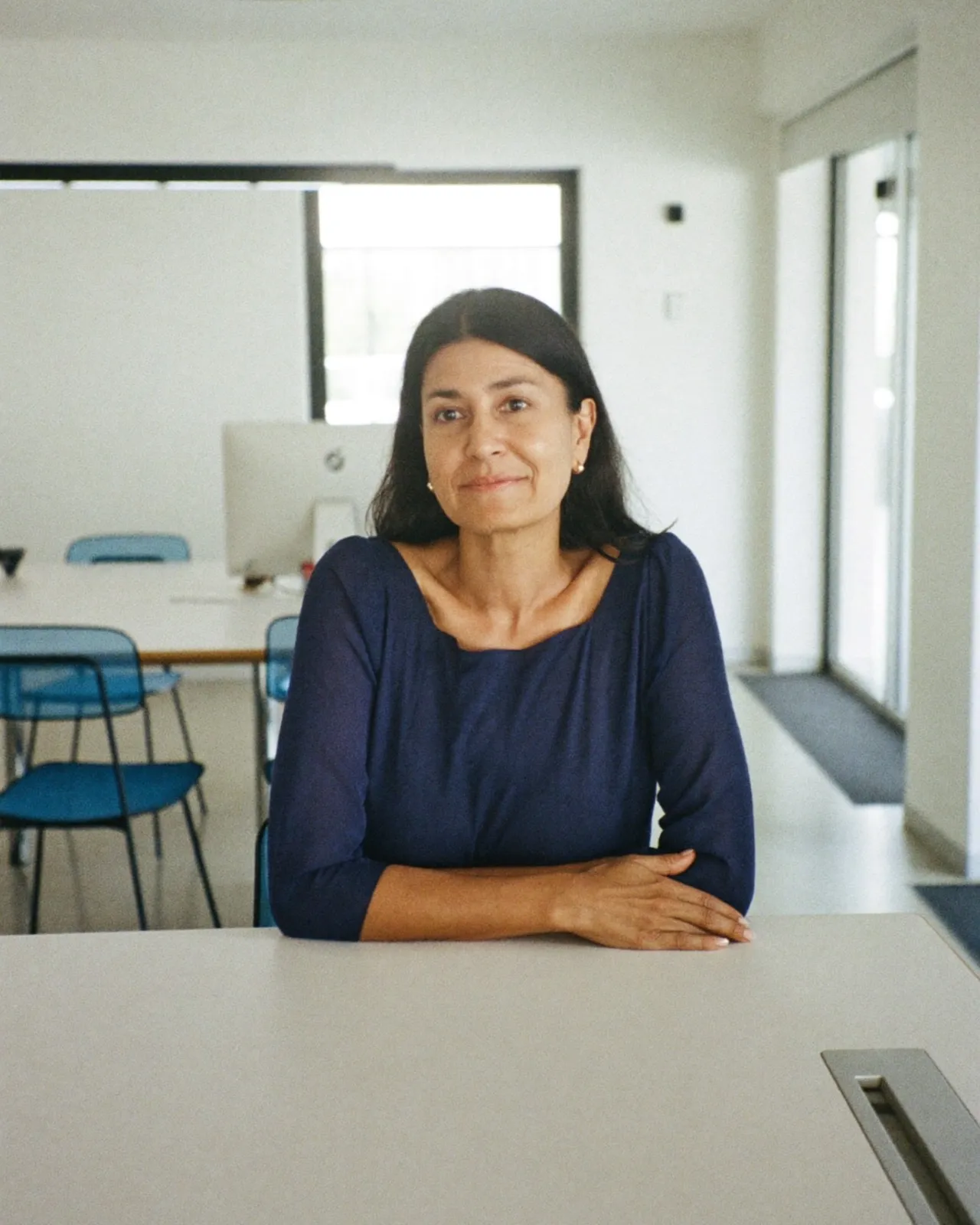 Imagen ilustrativa: consultora sentada al borde de una mesa de juntas