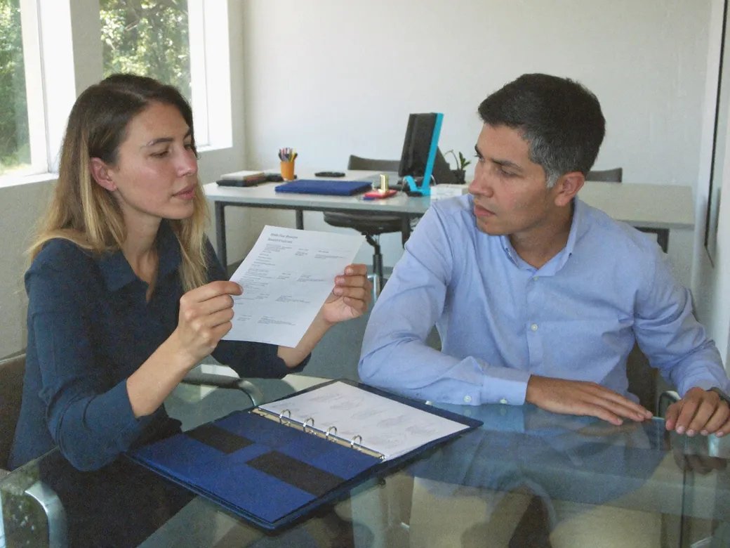Imagen ilustrativa: una consultora y un gerente revisan una lista de verificación impresa